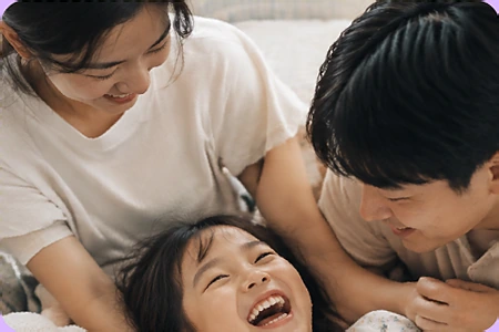 엄마 아빠와 함께 누워 활짝 웃는 아이